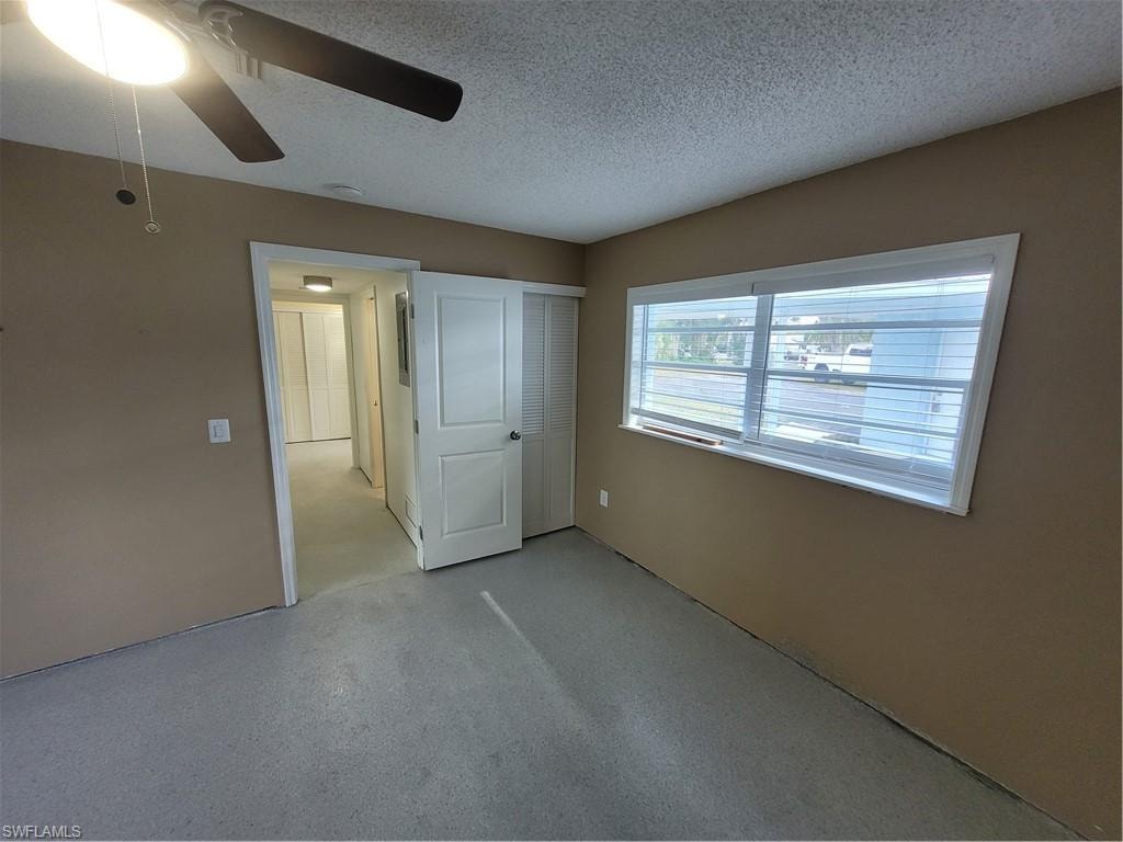 Unfurnished bedroom with a ceiling fan, a textured ceiling, and a closet