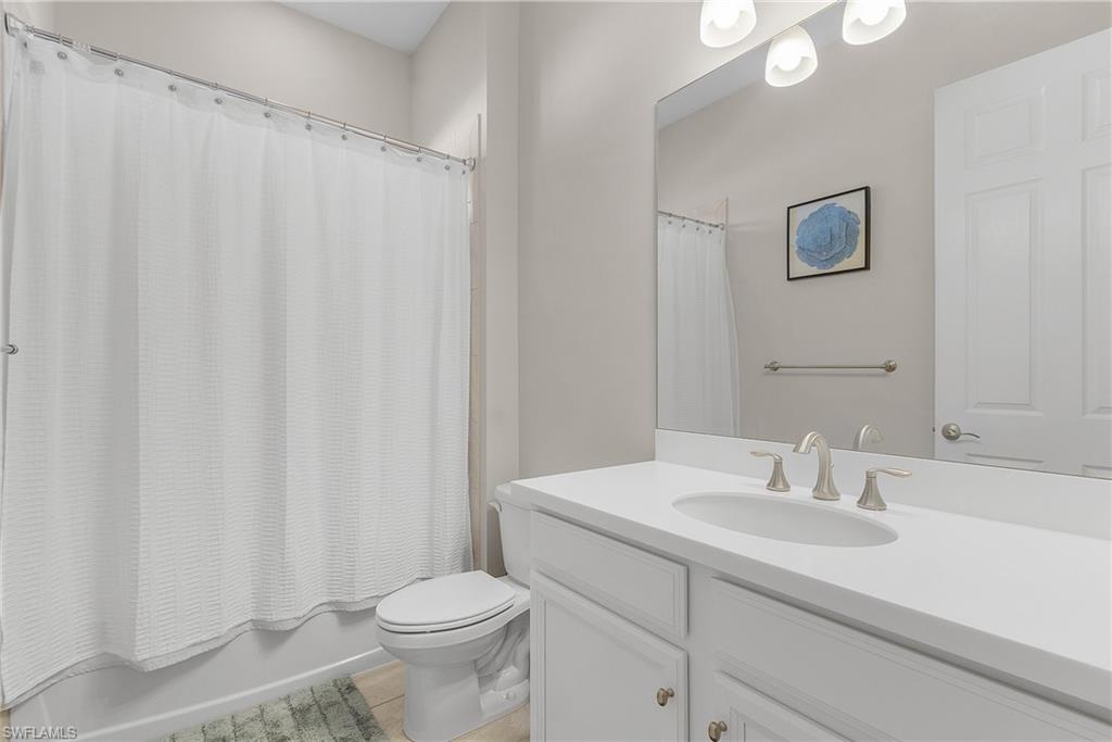Full bathroom featuring shower / bath combination with curtain and vanity