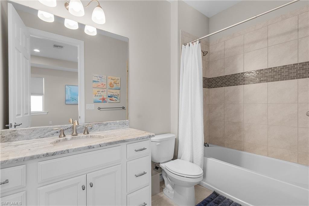 Upstairs Full bathroom featuring shower / bath combination with curtain, vanity, and light tile patterned floors