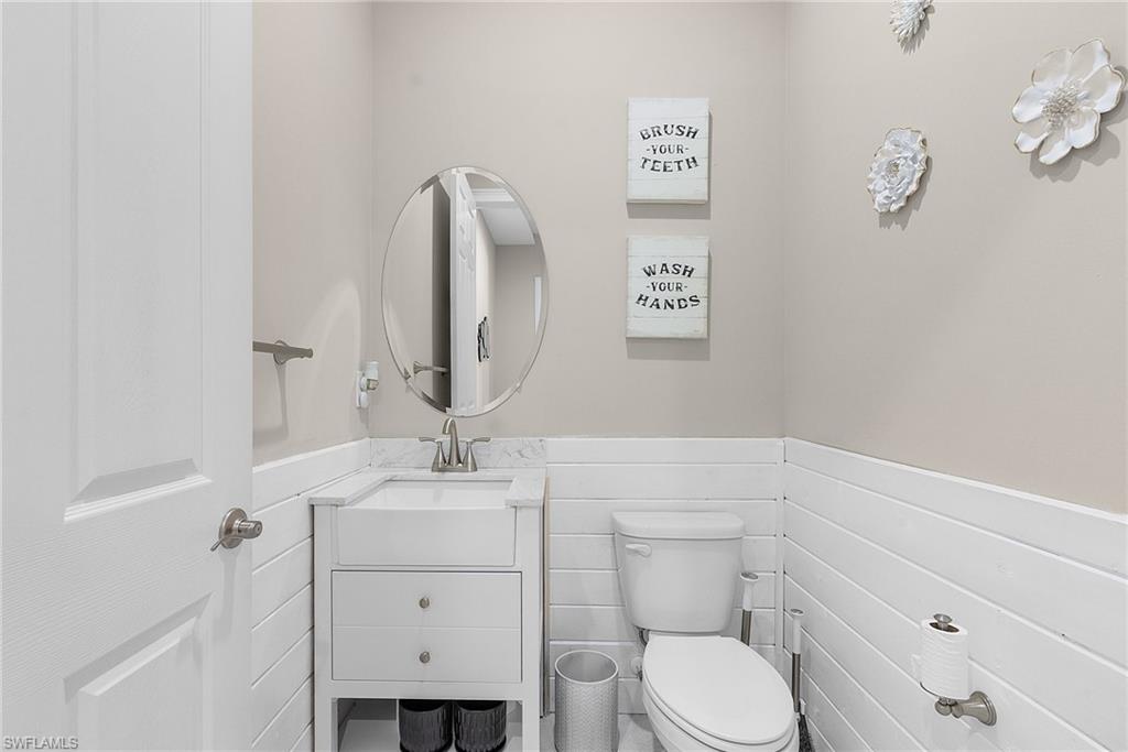 Downstairs half bathroom with wainscoting and vanity