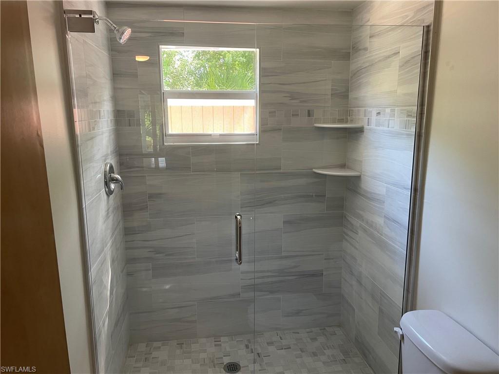 Bathroom featuring a stall shower and toilet