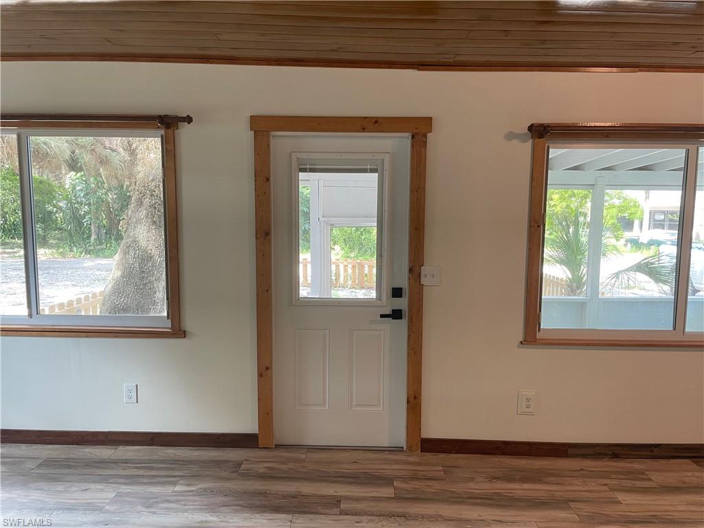 Doorway featuring wood finished floors and wood ceiling
