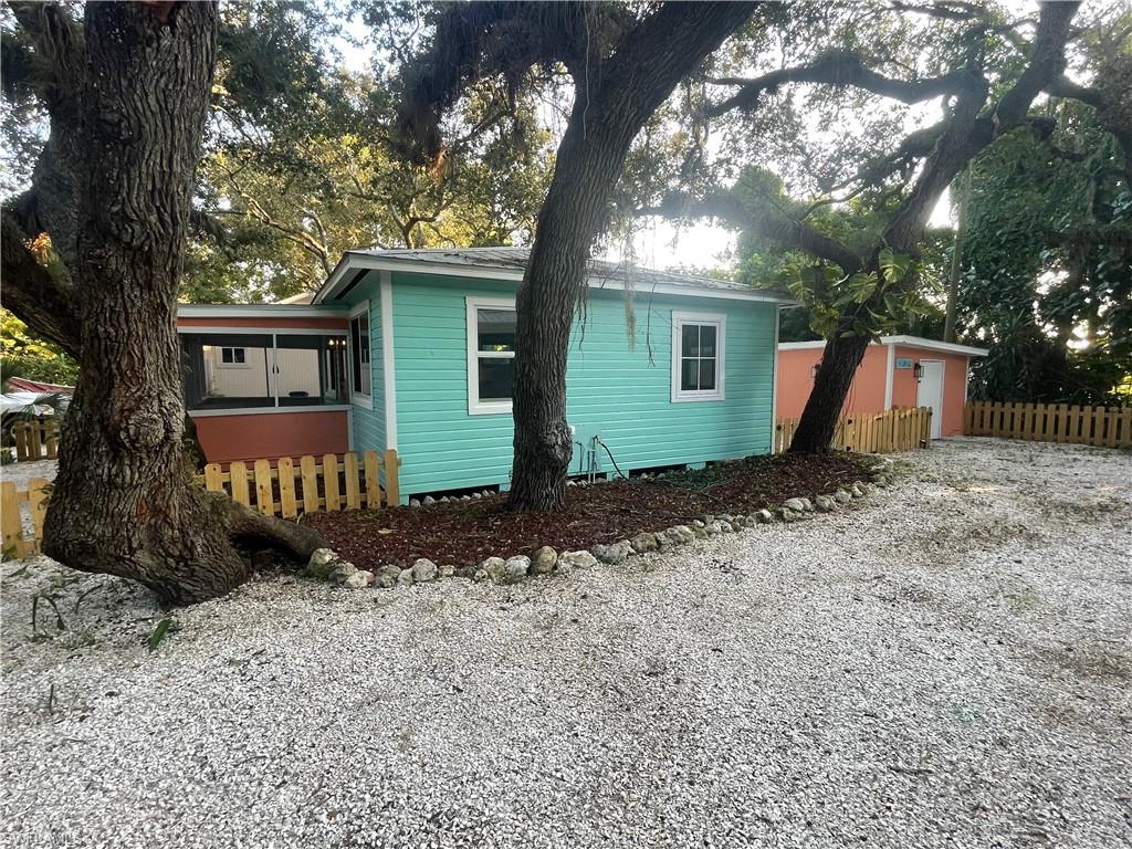 View of side of property featuring gravel driveway