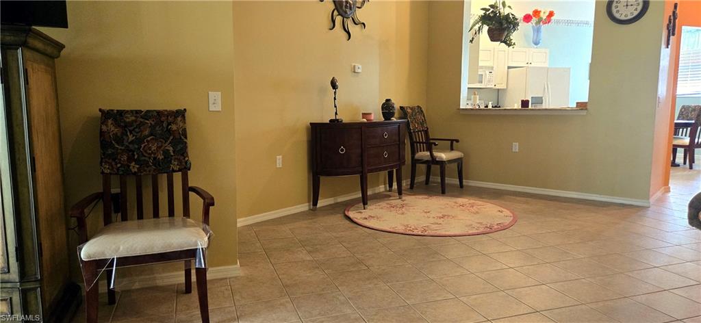 Living area with baseboards and light tile patterned flooring