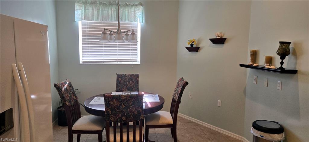 Dining room featuring light tile patterned floors and baseboards