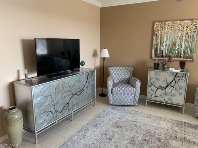 Living area with tile patterned flooring and crown molding