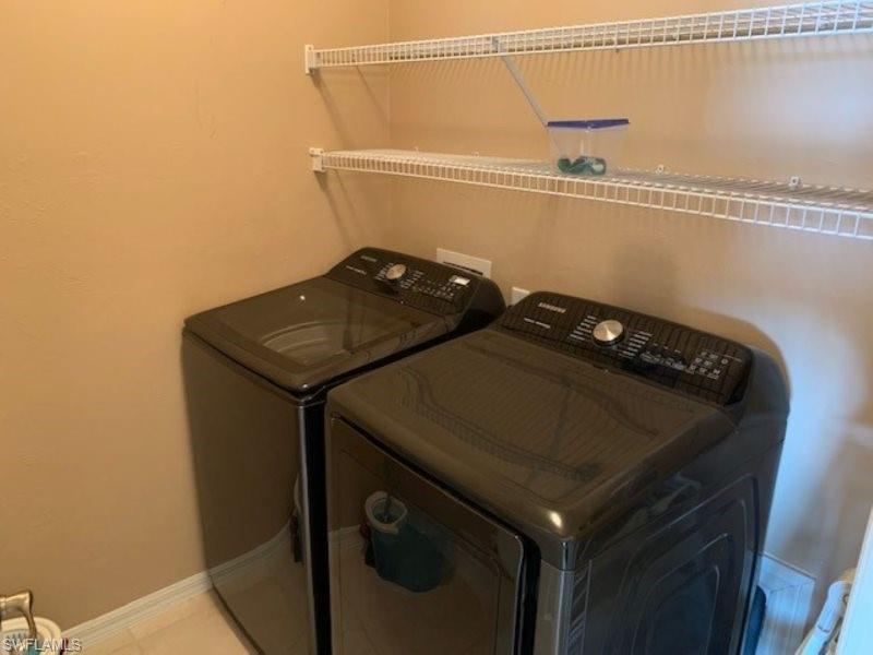 Laundry room featuring washing machine and dryer and tile patterned floors