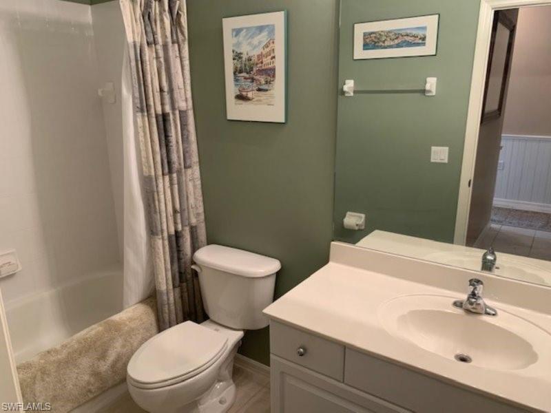 Bathroom with shower / bath combination with curtain and vanity