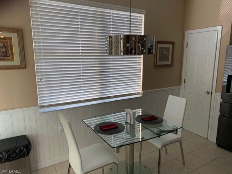 Dining area with wainscoting and light tile patterned floors