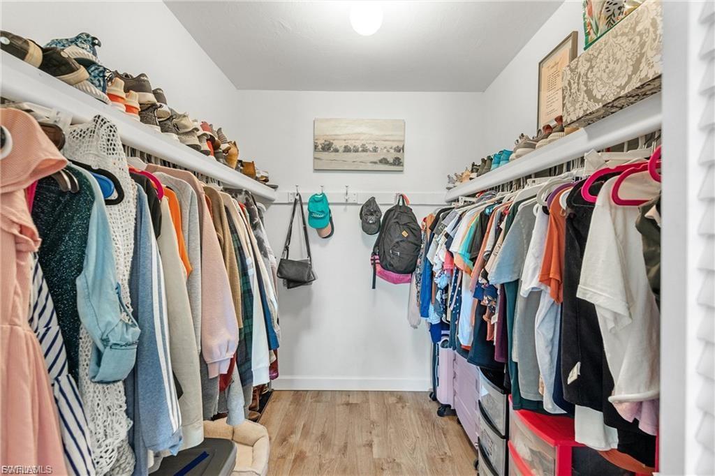 Walk in closet with light wood-style flooring