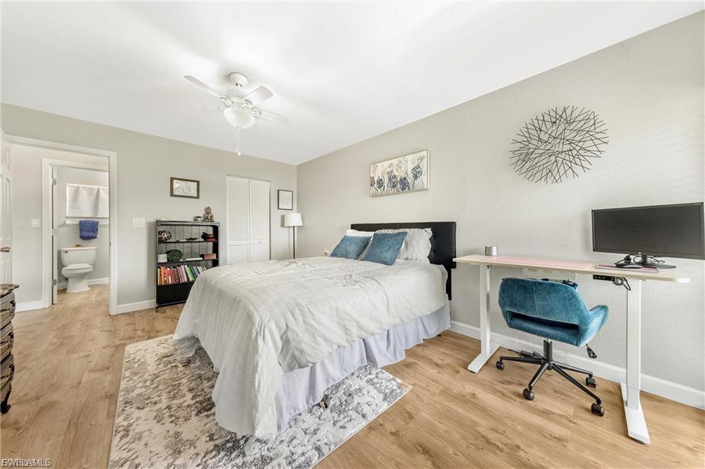 Bedroom with a closet, light wood-style floors, a desk, and a ceiling fan