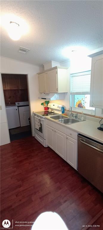 Kitchen featuring electric stove, a textured ceiling, stainless steel dishwasher, light countertops, and dark wood-style flooring