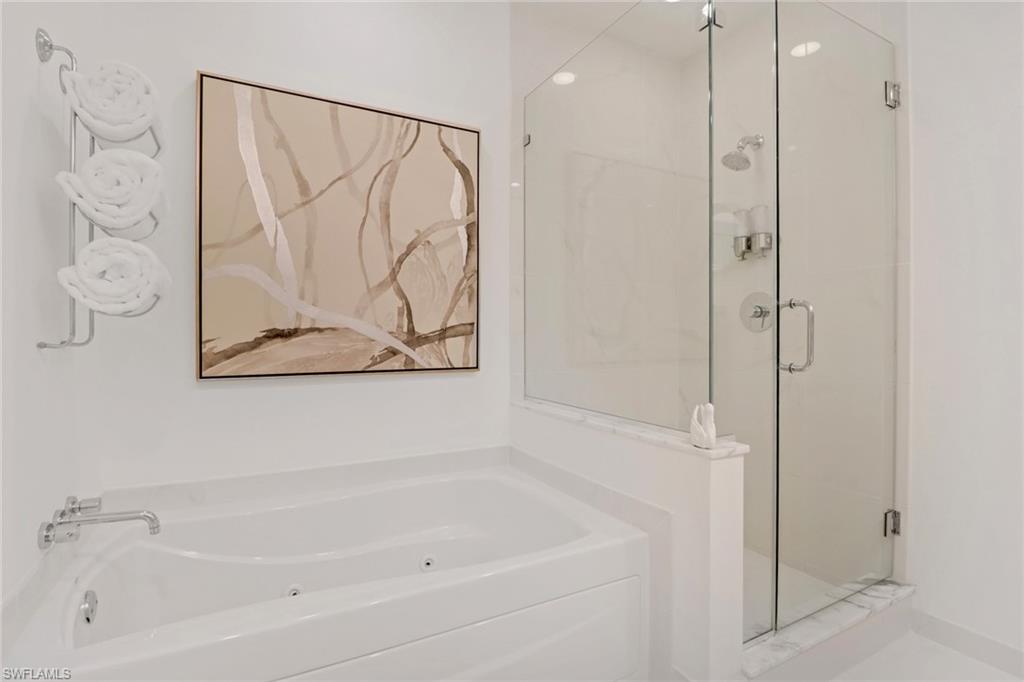 Bathroom with a glassed in shower and  jetted tub