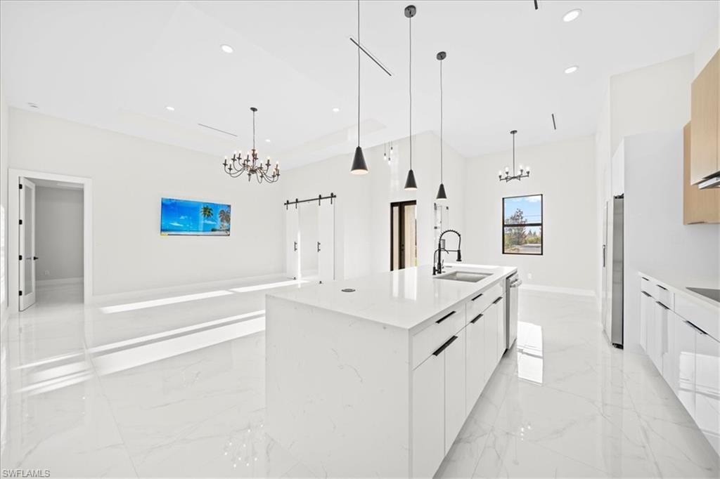 Kitchen featuring an island with sink, modern cabinets, white cabinets, and open floor plan