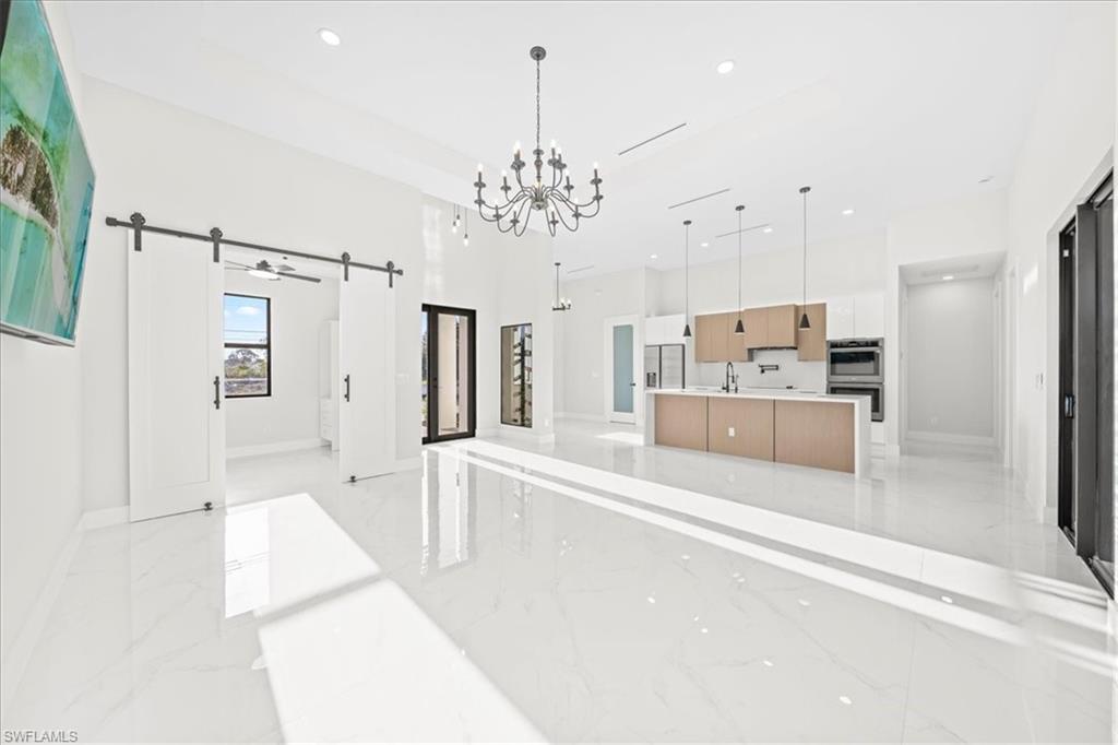 Empty room with recessed lighting, light marble finish floors, and a ceiling fan