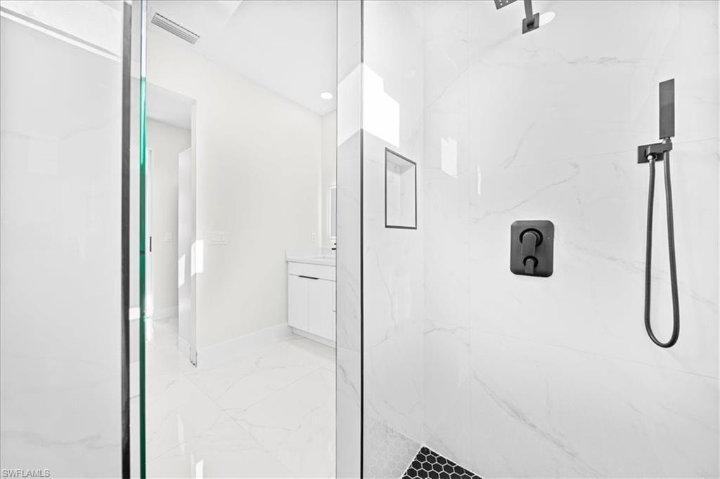 Walk in closet featuring light marble finish flooring