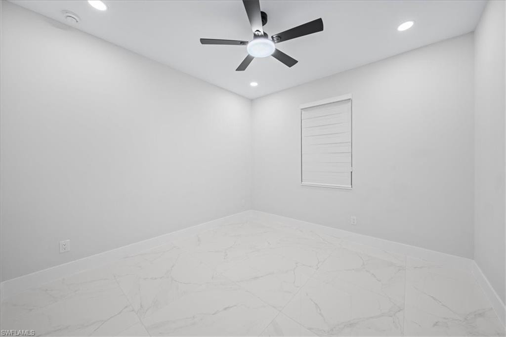 Bathroom featuring vanity, a marble finish shower, recessed lighting, and light marble finish floors