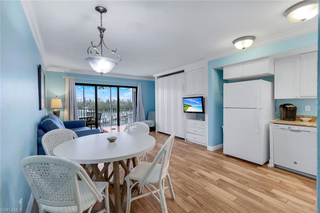 Dining room with ornamental molding and light hardwood / wood-style flooring