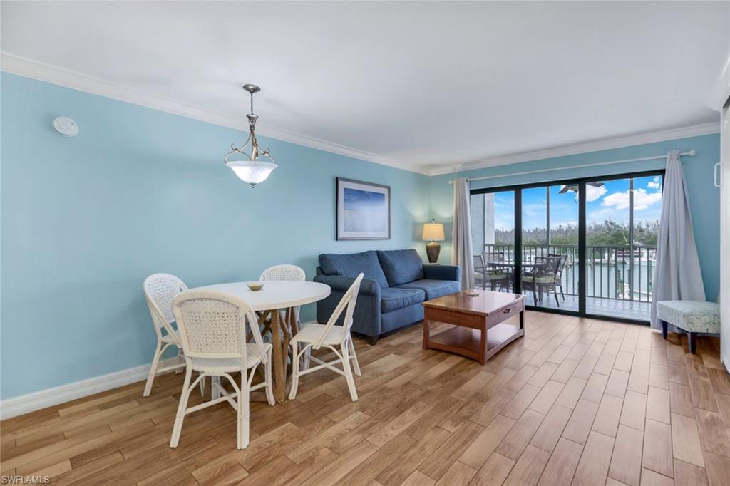 Living room featuring light hardwood / wood-style flooring, ornamental molding, and a water view