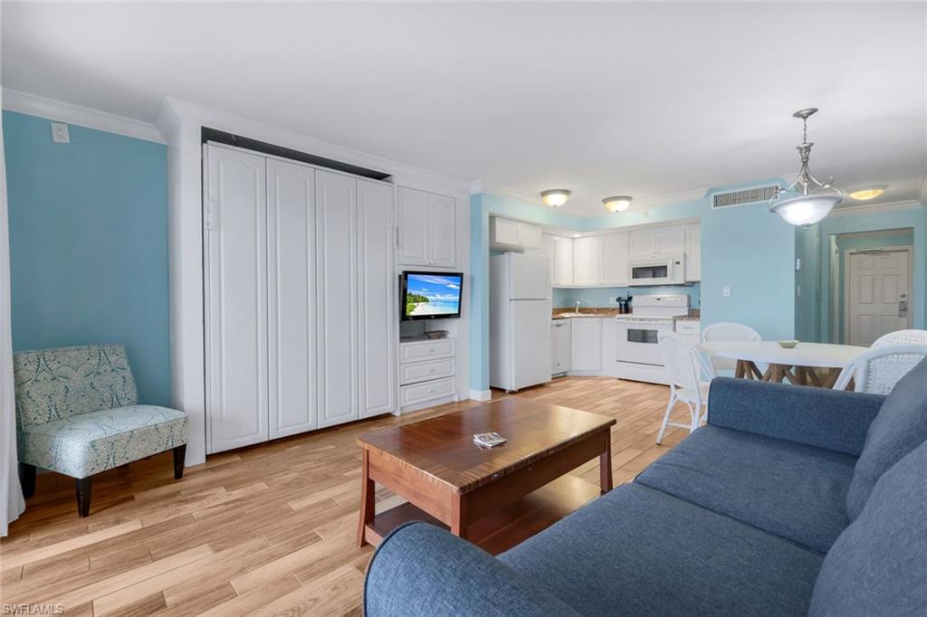 Living room with crown molding and light wood-type flooring