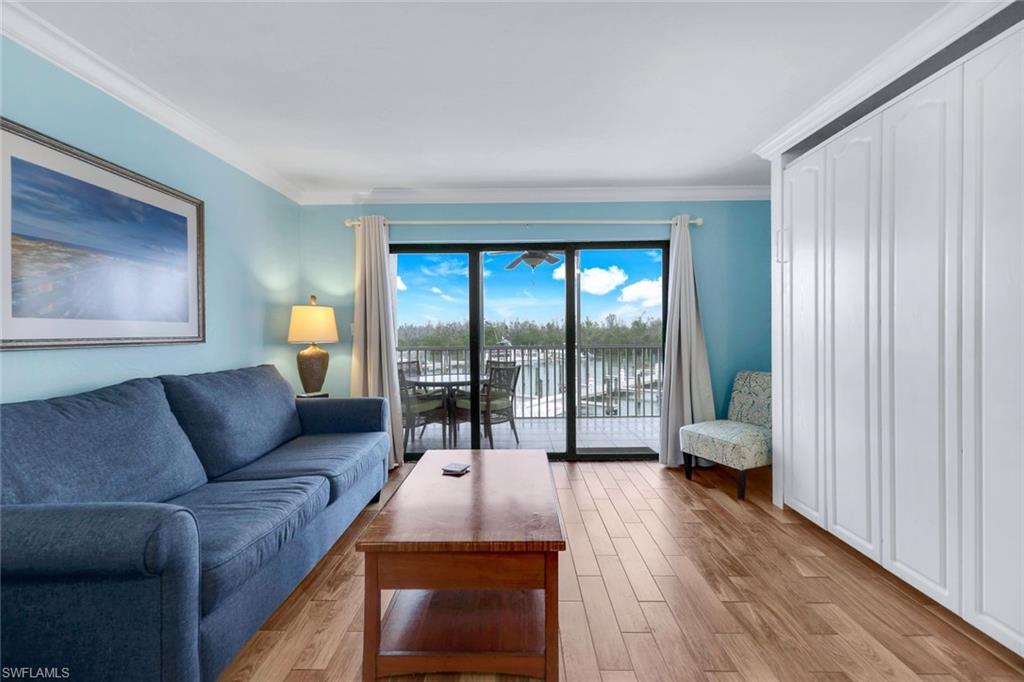 Living room with ornamental molding and light wood-type flooring