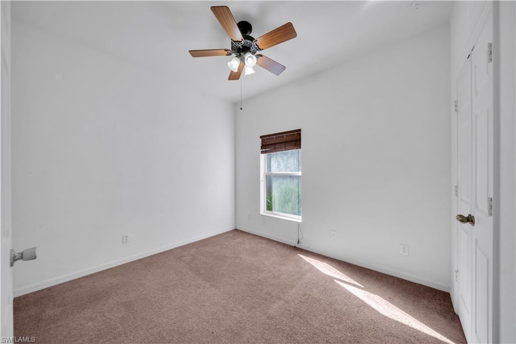 Unfurnished room featuring carpet floors and a ceiling fan