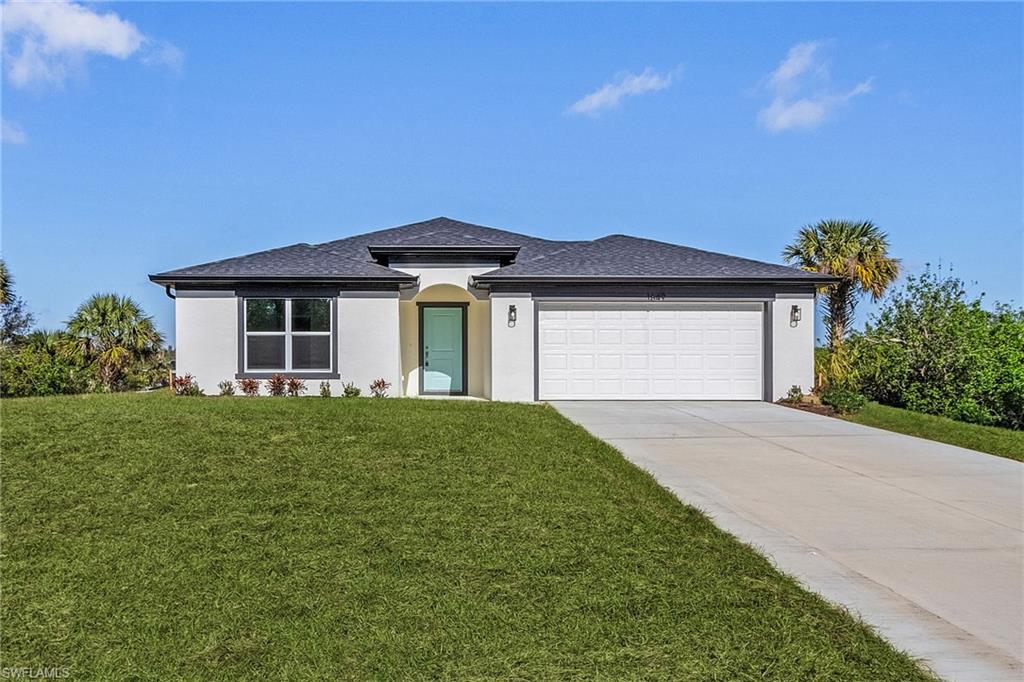 View of front of property featuring a front lawn and a garage