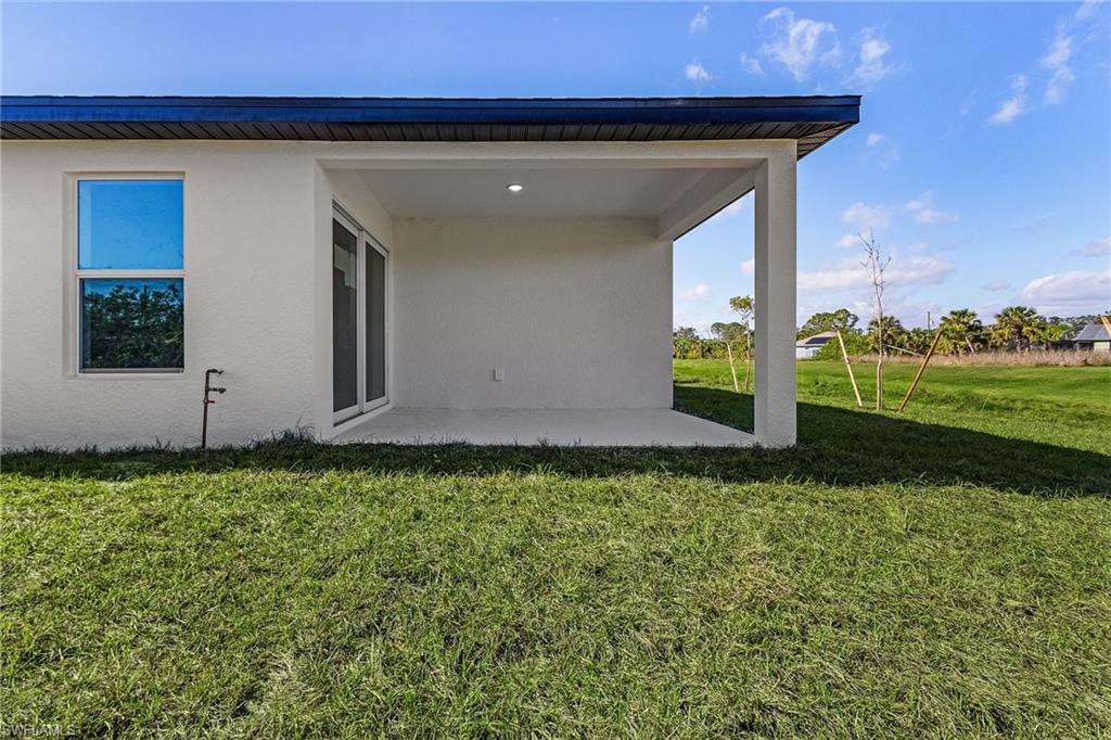 Back of property with a yard and a patio