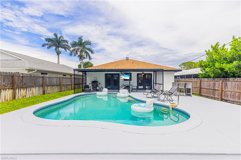 View of swimming pool with french doors, a fenced backyard, and a patio area
