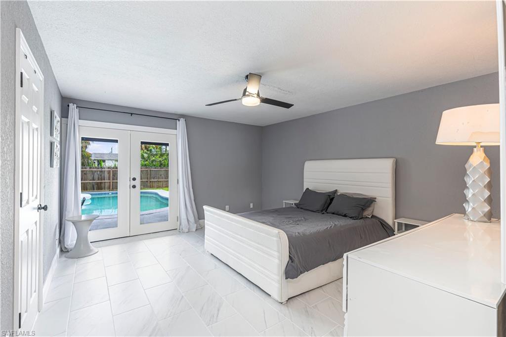 Bedroom with access to exterior, french doors, a ceiling fan, and a textured ceiling