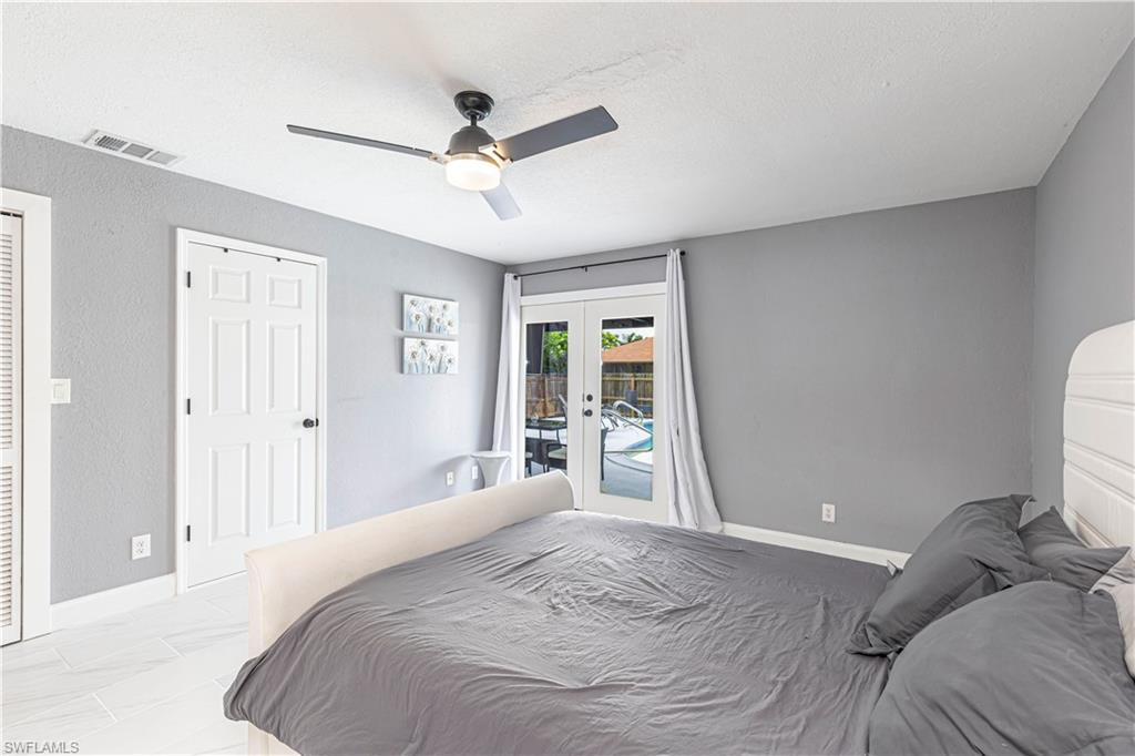 Bedroom featuring access to outside, a textured ceiling, a ceiling fan, french doors, and a textured wall