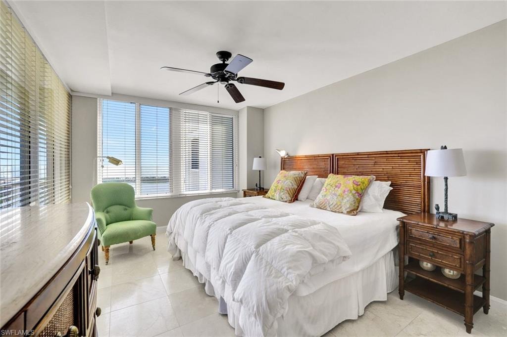 Bedroom with baseboards, light tile patterned flooring, and ceiling fan