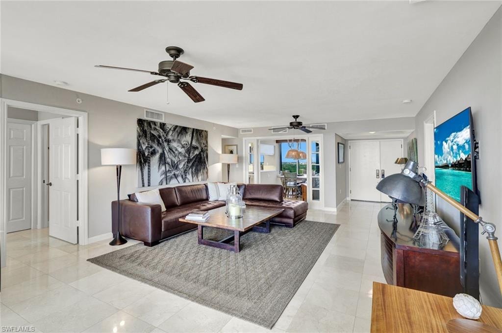 Living room featuring visible vents, ceiling fan, and baseboards
