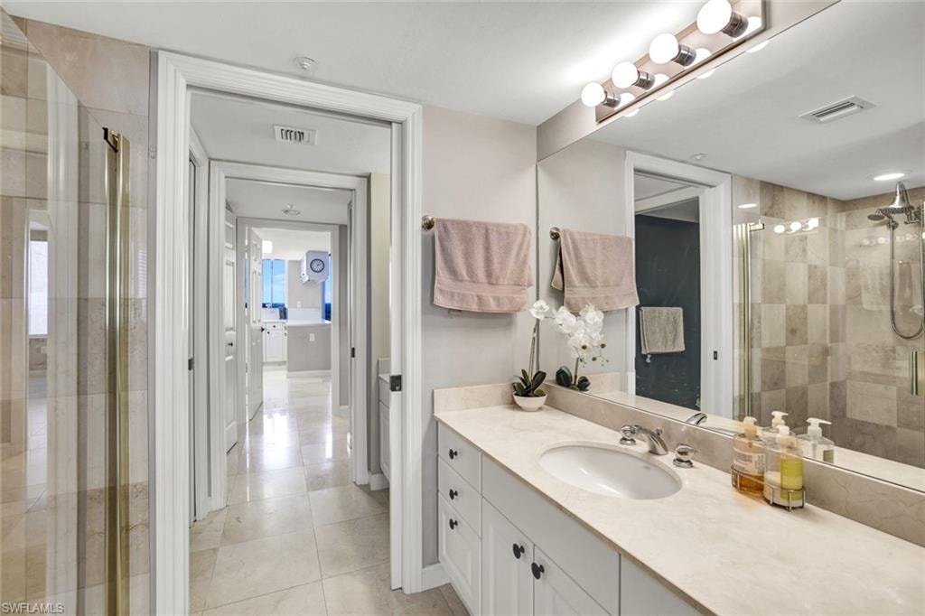 Bathroom with a stall shower, vanity, tile patterned flooring, and visible vents