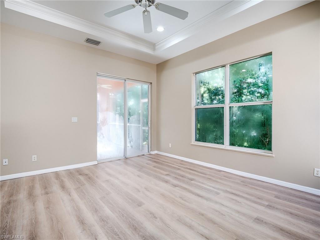 Unfurnished room featuring light wood-style flooring, ornamental molding, recessed lighting, and a tray ceiling
