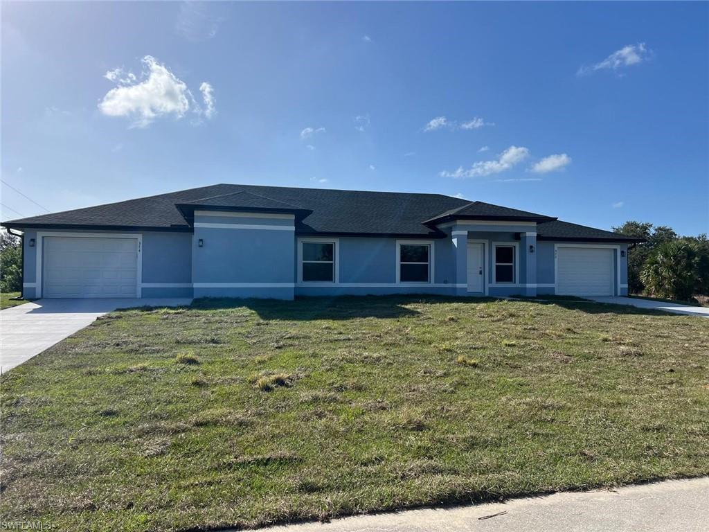 View of front of property featuring concrete driveway, a front lawn, stucco siding, an attached garage, and a shingled roof