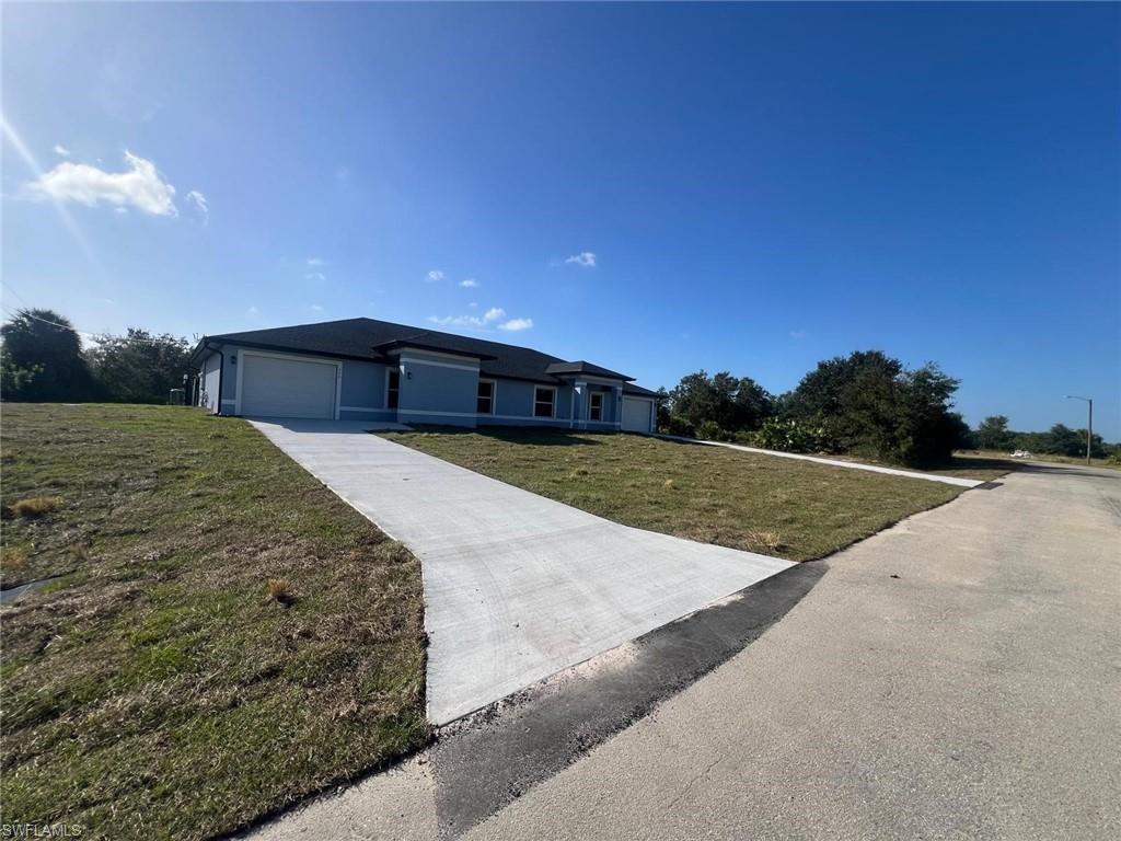View of front of home featuring a front lawn, a garage, and driveway