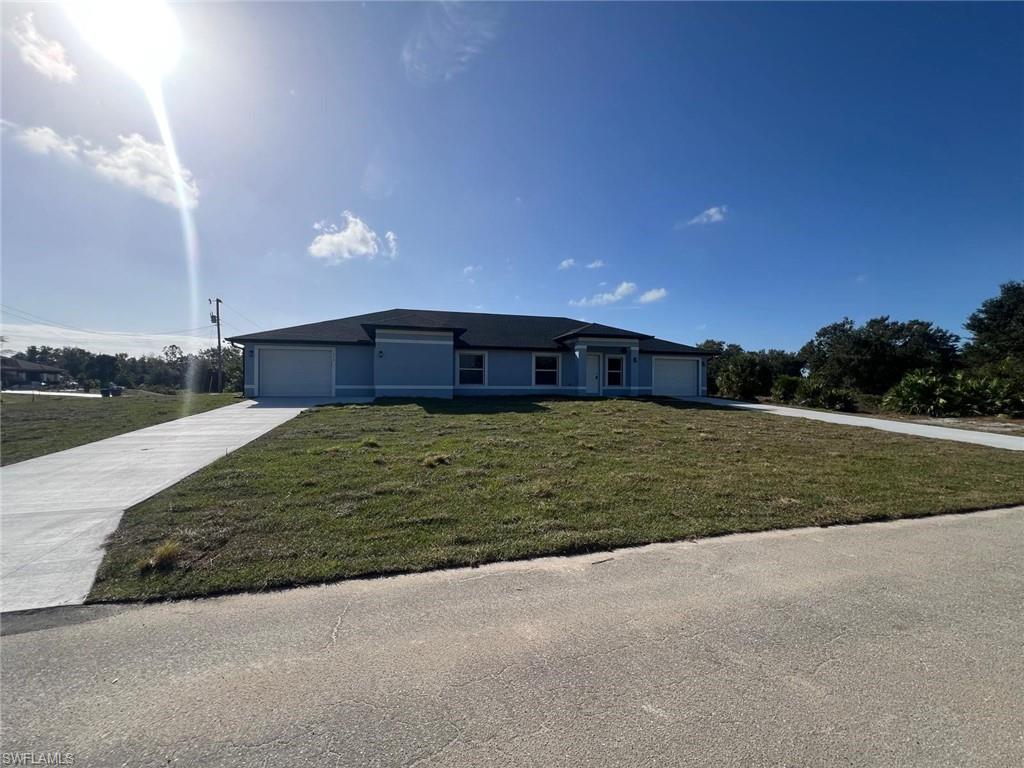 Single story home featuring a front lawn, driveway, and a garage