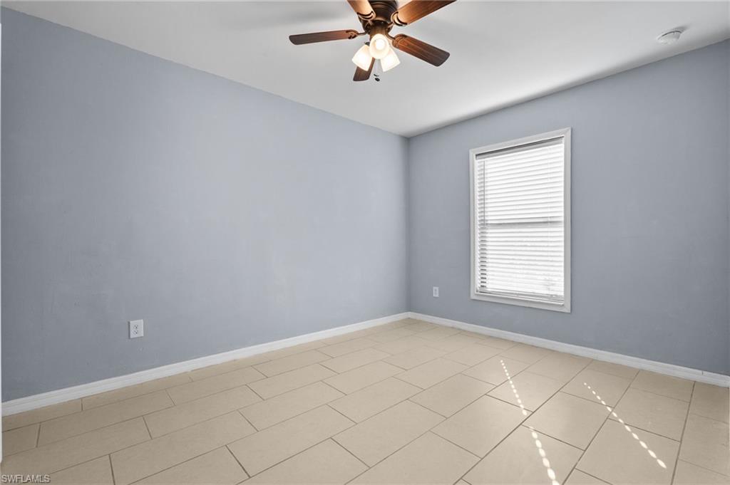 Empty room featuring baseboards and ceiling fan
