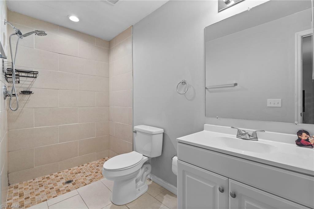Full bathroom with vanity, a stall shower, light tile patterned flooring, and recessed lighting