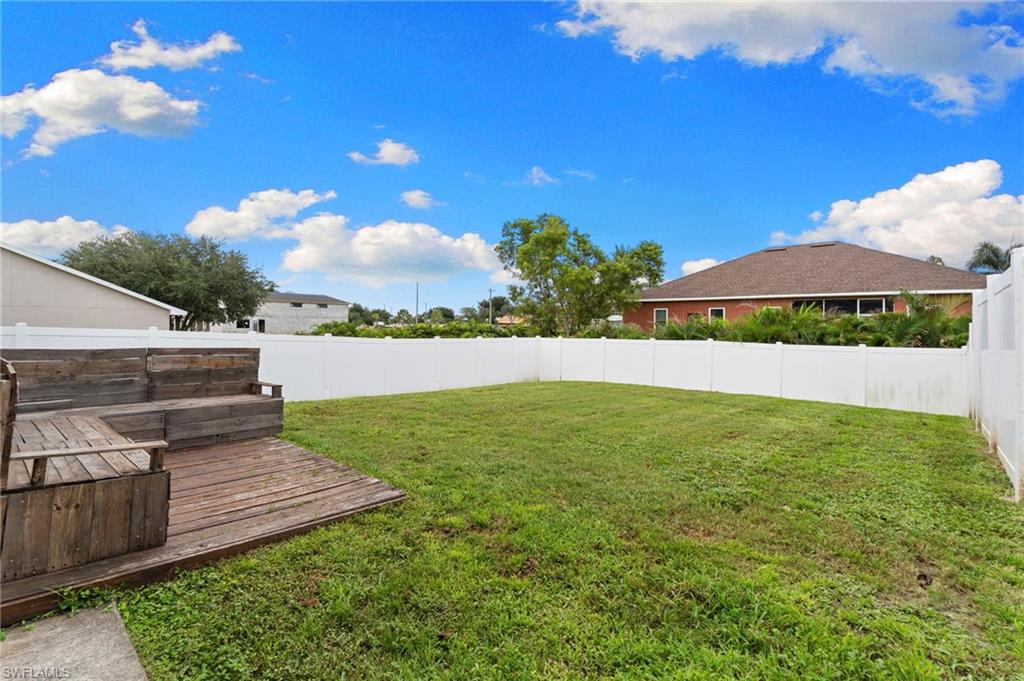 Fenced backyard featuring a deck