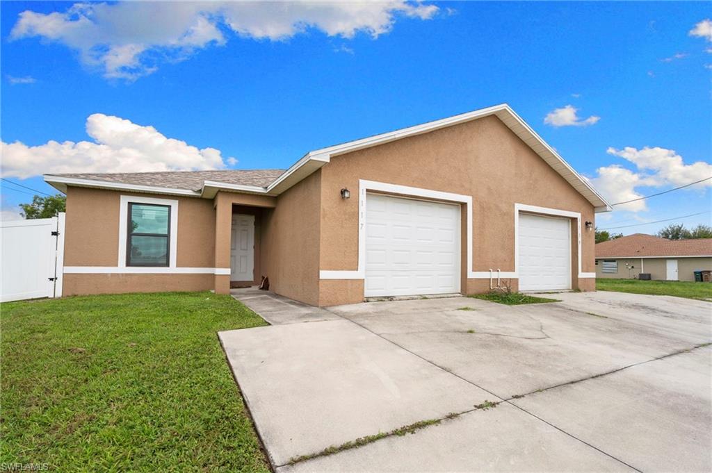 Single story home featuring stucco siding, a front yard, a gate, and concrete driveway
