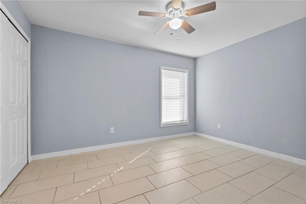 Unfurnished bedroom with a closet, ceiling fan, and light tile patterned flooring