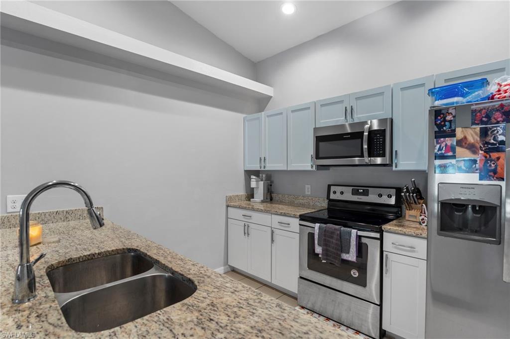 Kitchen featuring appliances with stainless steel finishes, light stone counters, recessed lighting, and light tile patterned floors