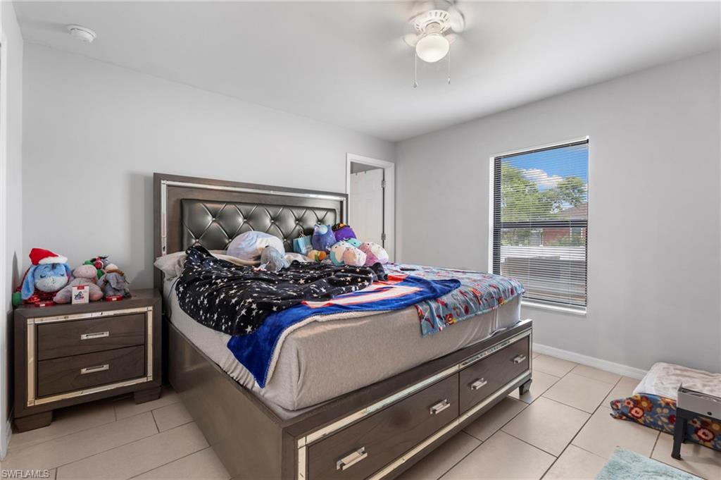 Bedroom with light tile patterned floors and ceiling fan
