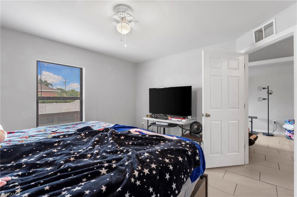 Bedroom with light tile patterned floors and a ceiling fan