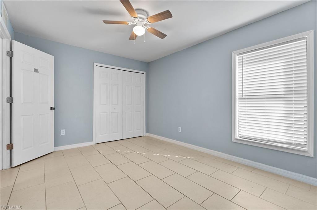 Unfurnished bedroom featuring ceiling fan, a closet, and light tile patterned floors