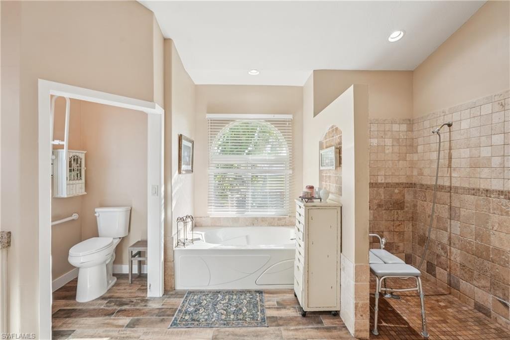 Full bathroom with a garden tub, a walk in shower, wood finish floors, and recessed lighting