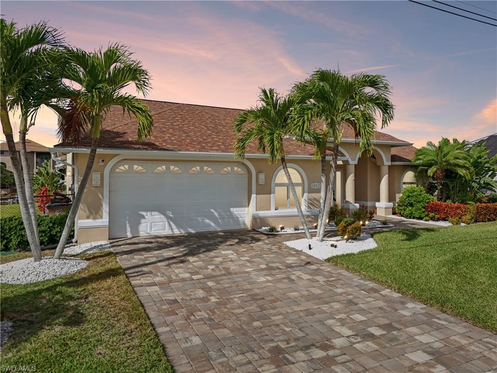 Mediterranean / spanish home with a yard, decorative driveway, a shingled roof, stucco siding, and an attached garage
