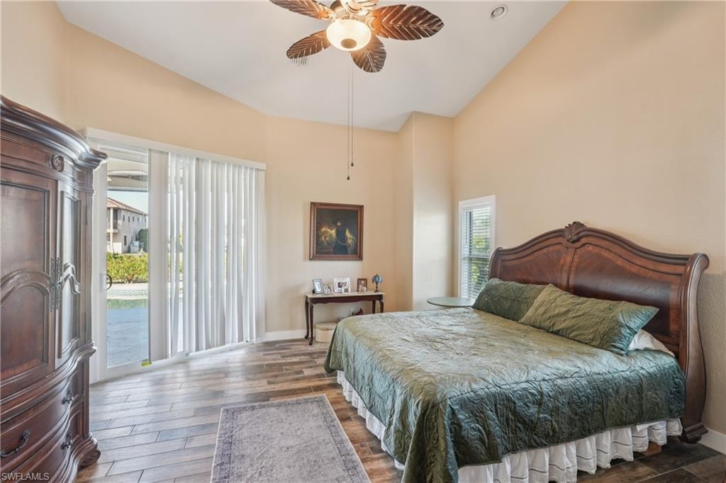 Bedroom featuring access to exterior, wood finished floors, a ceiling fan, and high vaulted ceiling